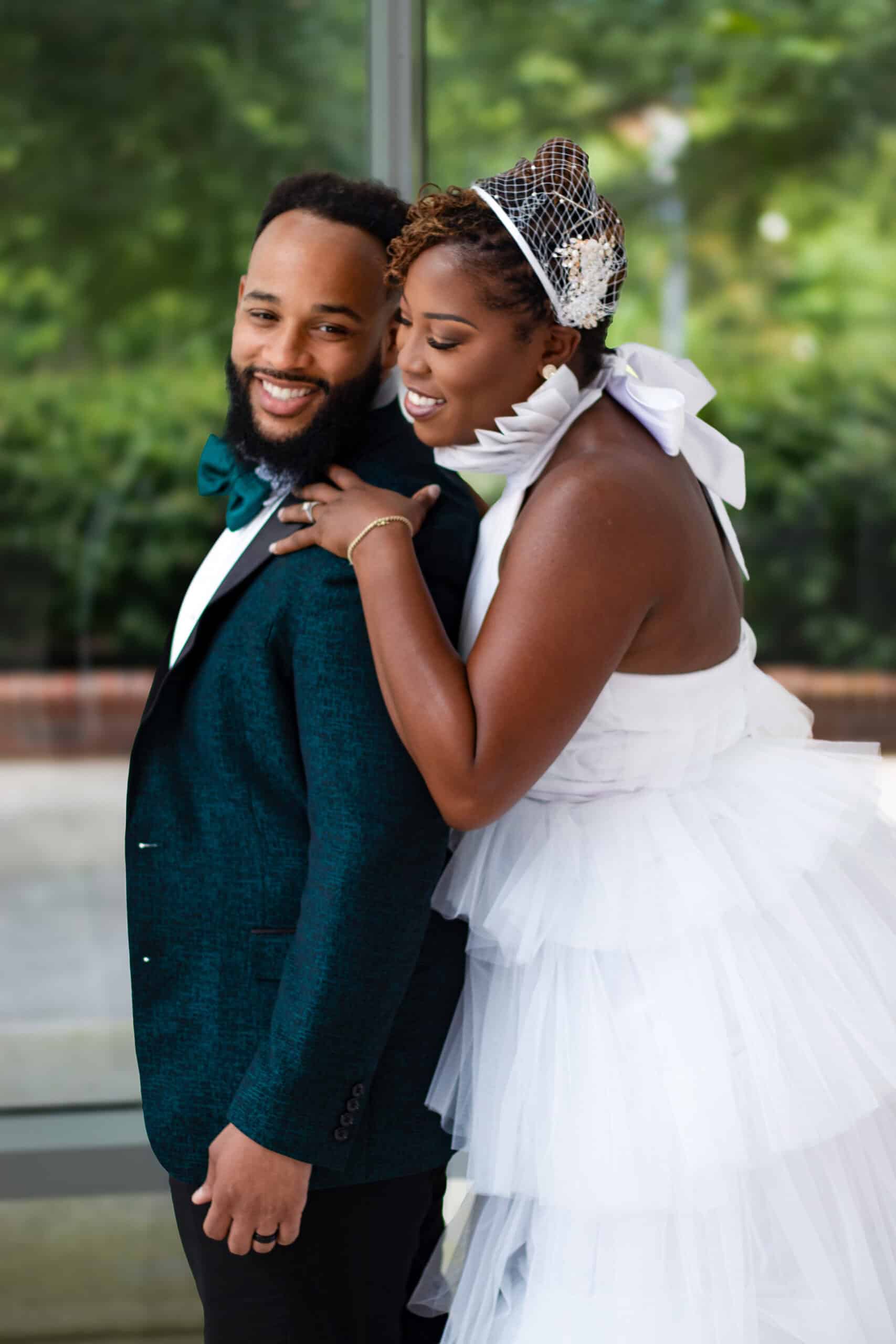Happy bride and groom embracing outdoors, wedding attire, joyful moment.